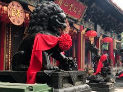 07B Statues of Chinese imperial guardian lion and a crane on the back of a dragon tortoise wearing a red sash scarf outside the main hall at Wong Tai Sin temple Hong Kong
